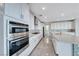 Kitchen with stainless steel appliances, an island with seating, and a modern backsplash at 1038 Delbrook Ave, Henderson, NV 89012