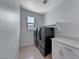 Compact laundry room features tile flooring, modern appliances, and a built-in storage cabinet at 1038 Delbrook Ave, Henderson, NV 89012