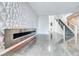Modern living area with decorative wall, fireplace, tile floors, and open staircase to the upper level at 1038 Delbrook Ave, Henderson, NV 89012