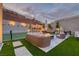 Backyard features a tennis court, outdoor kitchen, fire pit with lounge seating, and elegant hardscape with artificial turf at 11912 Skyline Arch Ct, Las Vegas, NV 89138