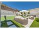 Backyard features a tennis court, outdoor kitchen, fire pit with lounge seating, and elegant hardscape with artificial turf at 11912 Skyline Arch Ct, Las Vegas, NV 89138