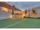 Outdoor basketball court featuring a well-lit entertaining area with string lights and manicured landscaping at 11912 Skyline Arch Ct, Las Vegas, NV 89138