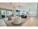 Bright, open-concept living space with modern chandelier, neutral furniture, and seamless indoor-outdoor flow to the patio at 11912 Skyline Arch Ct, Las Vegas, NV 89138