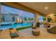 Luxury outdoor living area features a sparkling pool with water feature, covered patio, and comfortable seating at 11912 Skyline Arch Ct, Las Vegas, NV 89138
