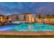 Stunning backyard showcasing a modern pool, spa with water features, and manicured landscaping under evening sky at 11912 Skyline Arch Ct, Las Vegas, NV 89138