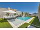 Beautiful pool area with lush green grass, modern water feature, and lounge seating at 11912 Skyline Arch Ct, Las Vegas, NV 89138