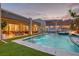 Stunning pool area with outdoor dining, lounge seating, and evening lighting at 11912 Skyline Arch Ct, Las Vegas, NV 89138