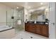 Modern bathroom featuring a double vanity, soaking tub, and a glass-enclosed shower at 135 E Harmon Ave # 3816, Las Vegas, NV 89109