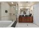 Modern bathroom featuring a double vanity, soaking tub, and a glass-enclosed shower at 135 E Harmon Ave # 3816, Las Vegas, NV 89109