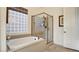 Serene bathroom with a soaking tub and glass-enclosed shower, complemented by neutral tones for a spa-like experience at 1869 Bronze Patina St, Henderson, NV 89044