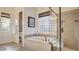 Elegant bathroom with a soaking tub and separate glass-enclosed shower, combining luxury and functionality at 1869 Bronze Patina St, Henderson, NV 89044
