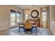 Elegant dining room with round table, stylish chairs, decorative mirror, and doors to the patio at 1869 Bronze Patina St, Henderson, NV 89044