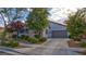 Well-maintained front exterior with a wide driveway, mature trees, and lush landscaping at 1869 Bronze Patina St, Henderson, NV 89044