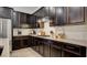 Sleek kitchen featuring dark cabinets, granite countertops, stainless steel appliances, and subway tile backsplash at 1869 Bronze Patina St, Henderson, NV 89044