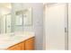 Bathroom with a shower and sink featuring wood-toned cabinets, with a mirrored wall above at 2143 Vista Famosa Ct, Las Vegas, NV 89123