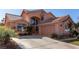 Charming two-story home featuring an attached garage, tile roof, arched windows, and well-maintained landscaping at 2143 Vista Famosa Ct, Las Vegas, NV 89123