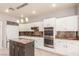 A kitchen with granite countertops and white cabinets with stainless steel appliances at 2143 Vista Famosa Ct, Las Vegas, NV 89123