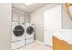 Bright laundry room with washer and dryer units, and a white sink with laminate countertop at 2143 Vista Famosa Ct, Las Vegas, NV 89123