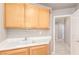 Bright laundry room with wooden cabinets, white countertop and sink, and tile flooring at 2143 Vista Famosa Ct, Las Vegas, NV 89123