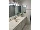 Bright bathroom featuring a white marble vanity and dual mirrors, complemented by sleek lighting fixtures at 2692 Matogroso Ln, Las Vegas, NV 89121