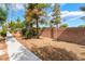 A block wall surrounds a yard that is xeriscaped with bushes, mulch and rock at 28 Yellow Flame Ave, North Las Vegas, NV 89084