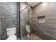 Modern shower featuring dark stone tile and a glass enclosure at 28 Yellow Flame Ave, North Las Vegas, NV 89084