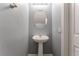 Charming powder room with pedestal sink, oval mirror, and modern fixtures at 28 Yellow Flame Ave, North Las Vegas, NV 89084