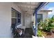 Charming front porch featuring a tile floor, seating area, plants, white brick exterior, and a secure screen door at 300 N 14Th St, Las Vegas, NV 89101
