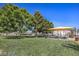 Community park featuring green lawn, mature trees, shade structure, picnic tables, and barbecue grills, offering a communal outdoor space at 3318 N Decatur Blvd # 2138, Las Vegas, NV 89130