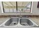 Close-up of a stainless steel kitchen sink with modern fixtures and a view from the window at 3936 Applecrest St, Las Vegas, NV 89108