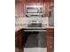 Close up of a stainless steel oven and microwave in a kitchen with brown cabinets at 3936 Applecrest St, Las Vegas, NV 89108