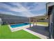 Relaxing backyard features a pool, covered patio and artificial grass at 4425 Sherrill Ave, Las Vegas, NV 89110