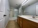 Well-lit bathroom with a shower-tub combination and wooden vanity with a large mirror at 4749 Golden Shimmer Ave, Las Vegas, NV 89139