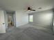 Cozy bedroom with neutral carpet, a ceiling fan, and an open view to an attached bathroom at 4749 Golden Shimmer Ave, Las Vegas, NV 89139