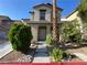 Two-story home has a small front yard with decorative landscaping and is near a palm tree at 4749 Golden Shimmer Ave, Las Vegas, NV 89139