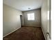 Neutral bedroom with brown carpet, natural light from one window, and standard door at 5524 Markley Ave, Las Vegas, NV 89141