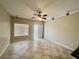 Bright living room featuring tile floors, neutral walls, ceiling fan, and sliding glass doors to the backyard at 5524 Markley Ave, Las Vegas, NV 89141
