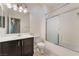 Bathroom features a dark vanity, toilet, and shower-tub combo with glass doors at 5586 Golden Leaf Ave, Las Vegas, NV 89122