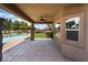 Covered patio with ceiling fan looks out to the backyard lawn and pool at 5586 Golden Leaf Ave, Las Vegas, NV 89122