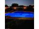 Inviting backyard pool featuring custom lighting, a waterfall feature, and mature landscaping providing privacy at 5586 Golden Leaf Ave, Las Vegas, NV 89122