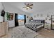 Bright bedroom featuring a checkered duvet, ceiling fan, and a view of the neighborhood at 6108 Shallow Springs St, Las Vegas, NV 89130
