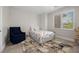 Comfortable bedroom featuring a blue armchair, neutral patterned carpet and a window at 631 Coriander Canyon Ct, Las Vegas, NV 89138