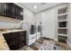 Well-equipped laundry room with a sink, washer, dryer, and storage shelves at 631 Coriander Canyon Ct, Las Vegas, NV 89138