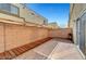 This backyard features a covered patio area, a brick perimeter, and privacy at 6320 Desert Leaf St # 101, North Las Vegas, NV 89081