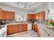 Modern kitchen featuring granite counters, stylish backsplash, and wood cabinets at 6320 Desert Leaf St # 101, North Las Vegas, NV 89081