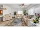 Open-concept living room with neutral decor, a ceiling fan, large windows, and an area rug at 6320 Desert Leaf St # 101, North Las Vegas, NV 89081