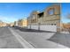 Street view showing attached garages and a row of two-story townhomes on a clear day at 6320 Desert Leaf St # 101, North Las Vegas, NV 89081