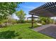 Lush backyard with a manicured lawn, covered patio, and decorative landscaping for outdoor enjoyment at 6338 Skystone St, Las Vegas, NV 89135