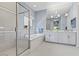 A luxurious bathroom features a soaking tub, glass shower, and double sink vanity with modern fixtures and ample counter space at 6338 Skystone St, Las Vegas, NV 89135