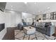 Open-concept living room featuring a fireplace, stairs, and leading into the kitchen, with a large gray sectional at 6338 Skystone St, Las Vegas, NV 89135